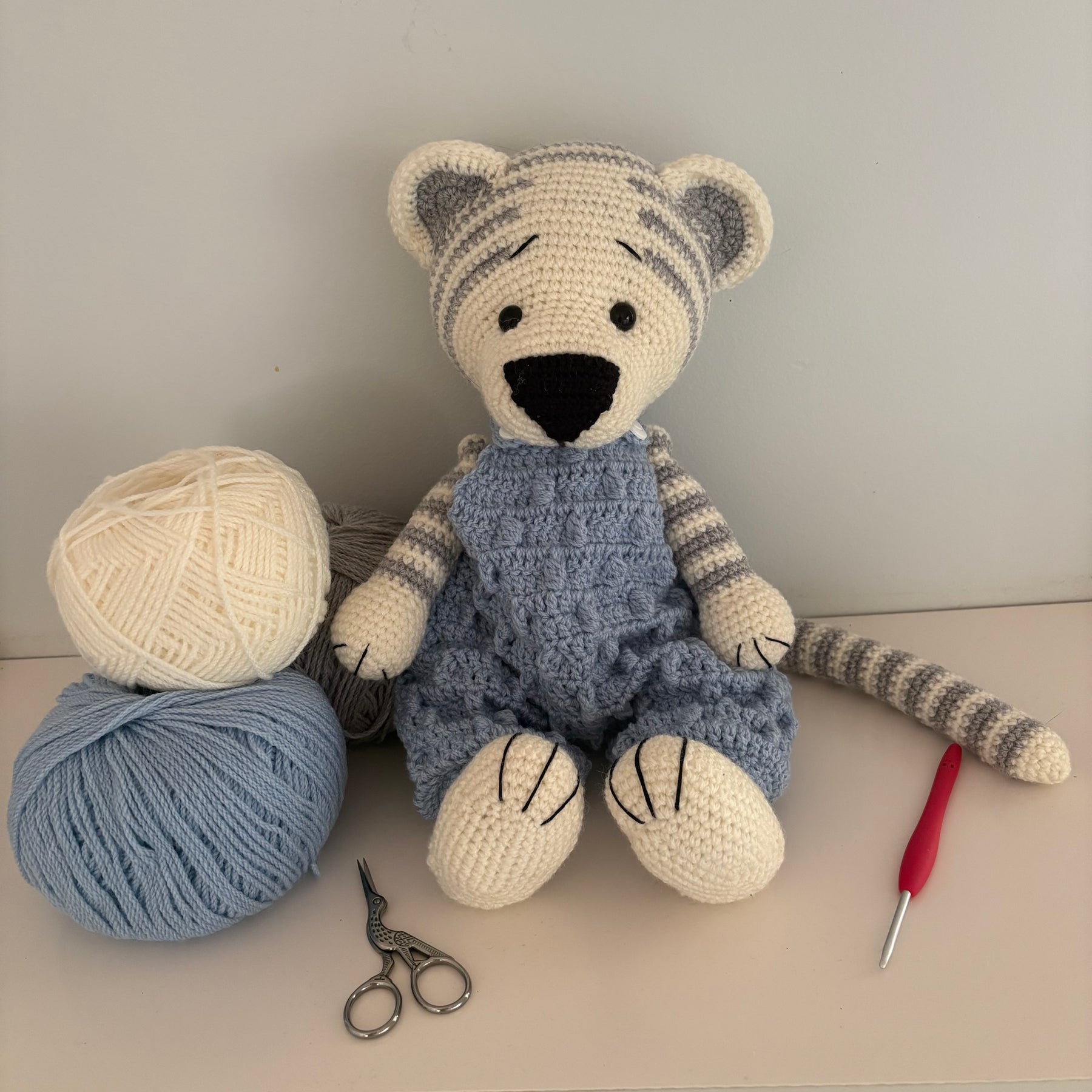 Crochet tiger in blue overalls