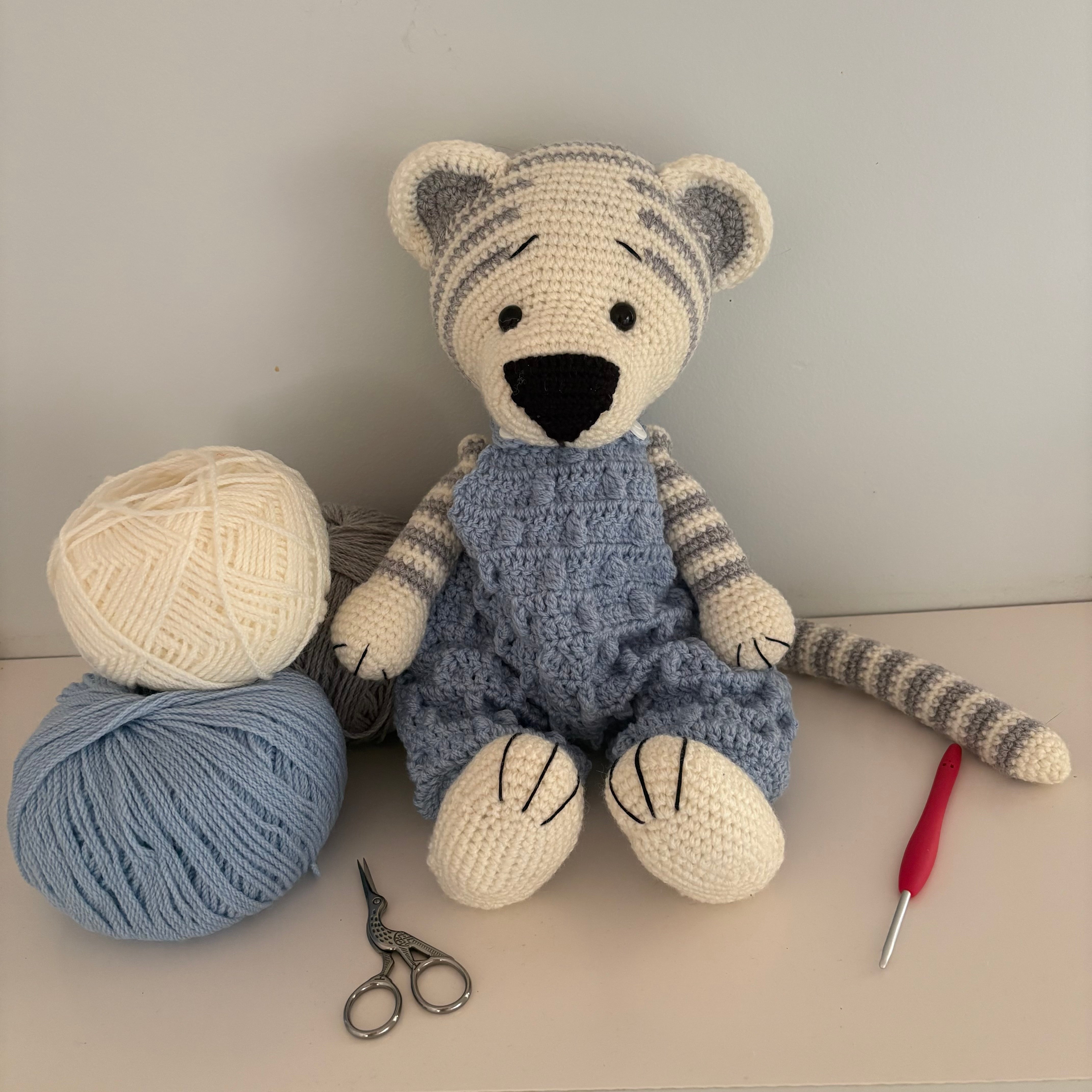 Crochet tiger in blue overalls