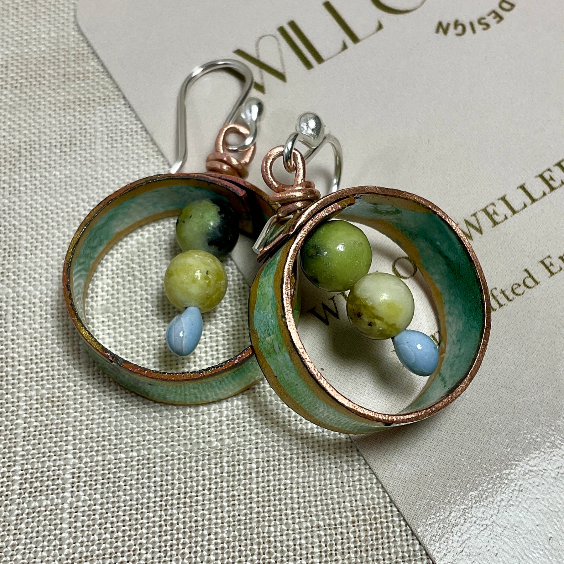 Teal gold and white enamel earrings with gemstone beads.