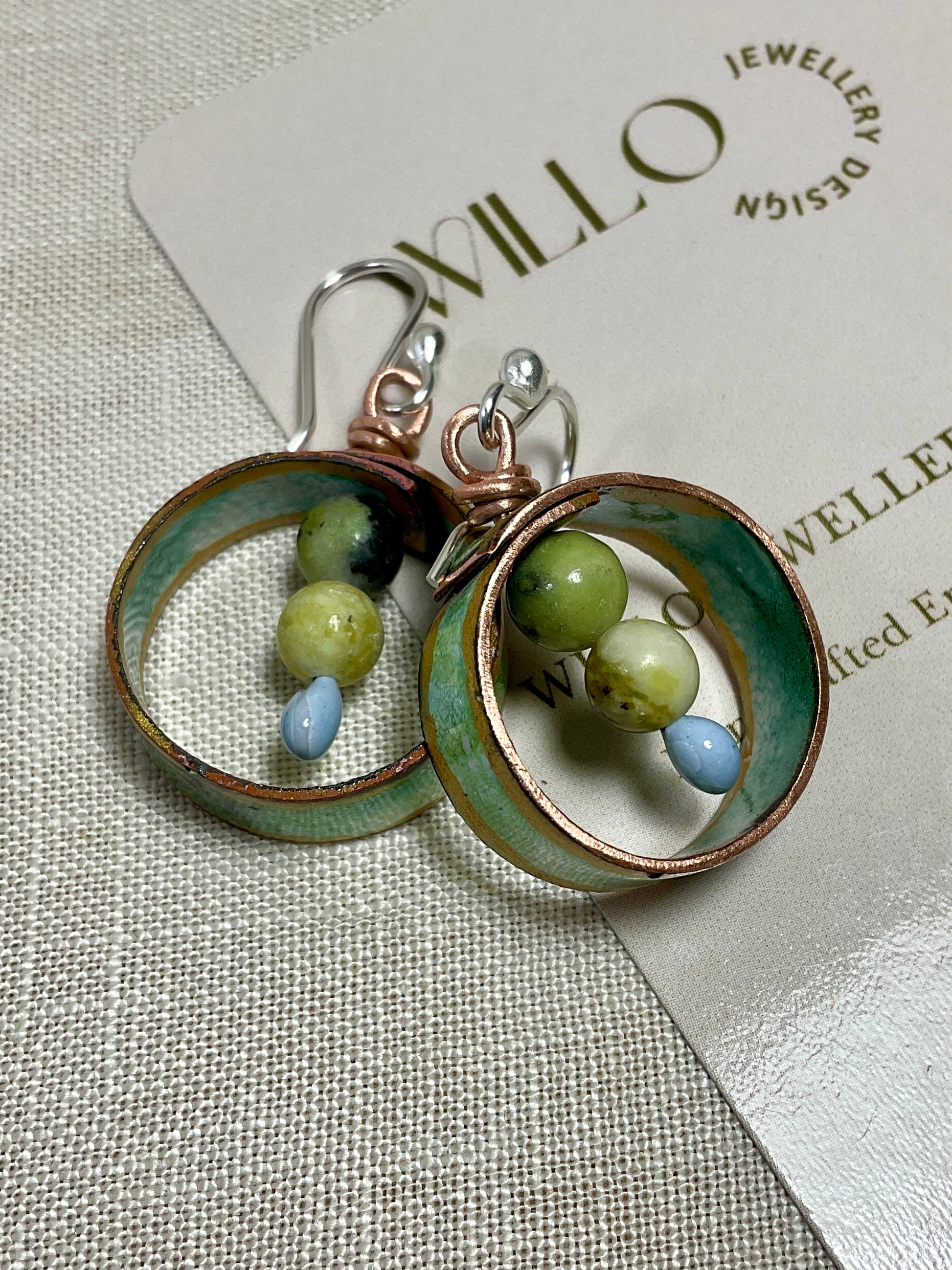 Teal gold and white enamel earrings with gemstone beads.