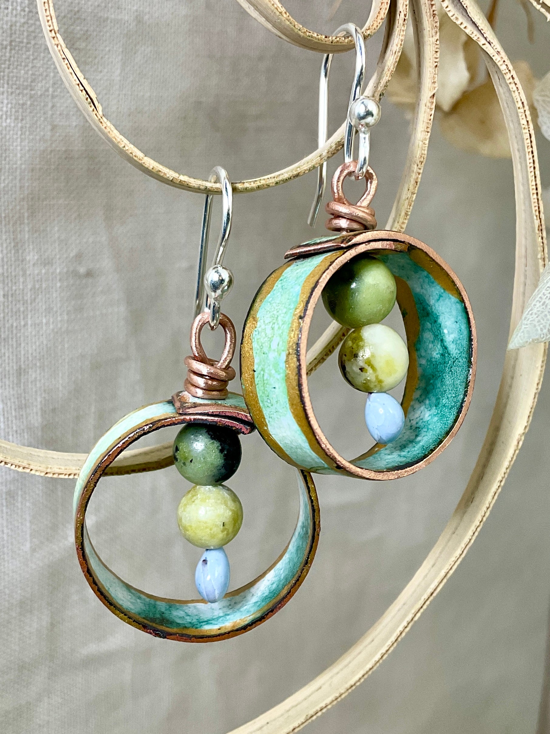 Teal gold and white enamel earrings with gemstone beads.