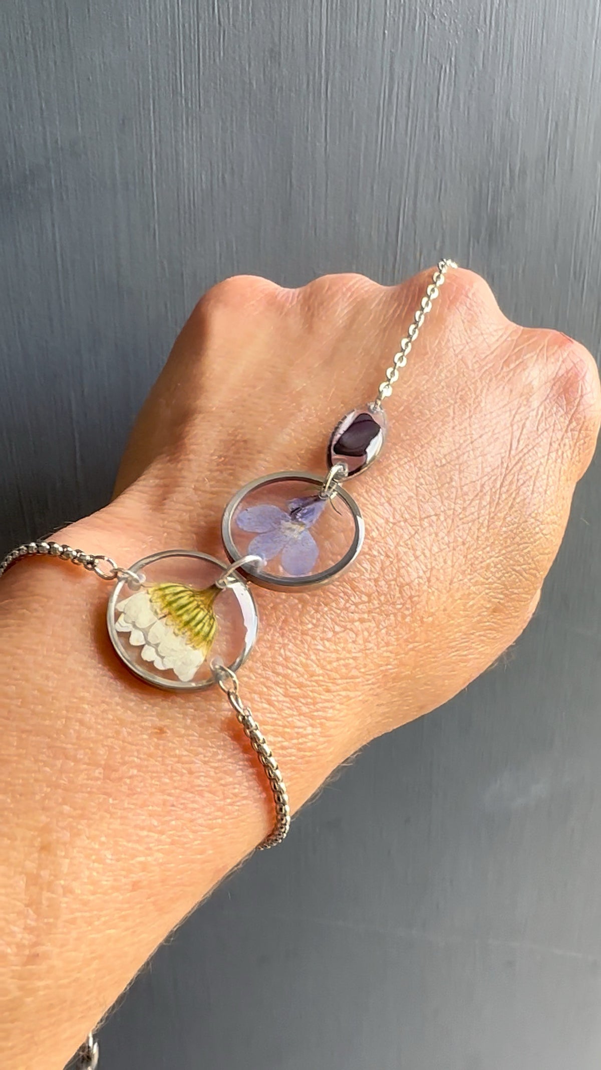 Botanical resin hand chain in silver with pressed flowers and cowrie shell