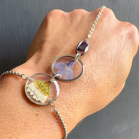 Botanical resin hand chain in silver with pressed flowers and cowrie shell