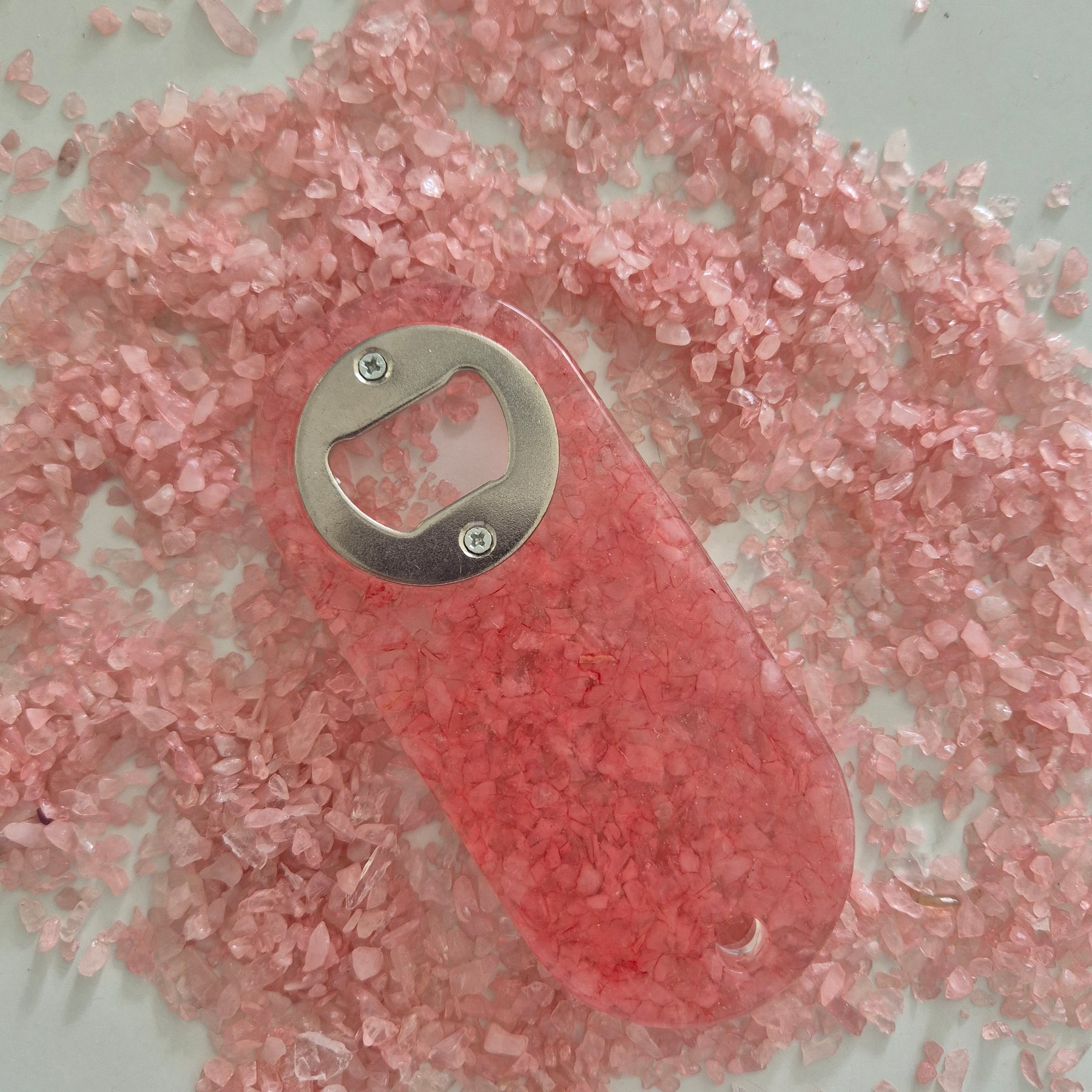 Resin bottle opener with inlaid rose quartz stones