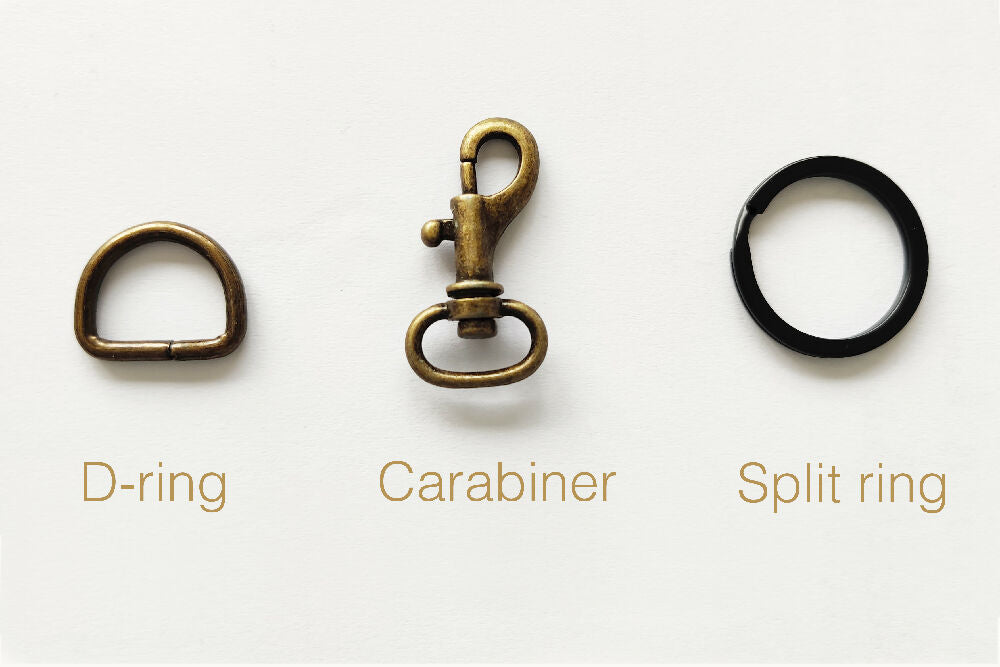A brass d-ring, a brass carabiner and a black split ring.