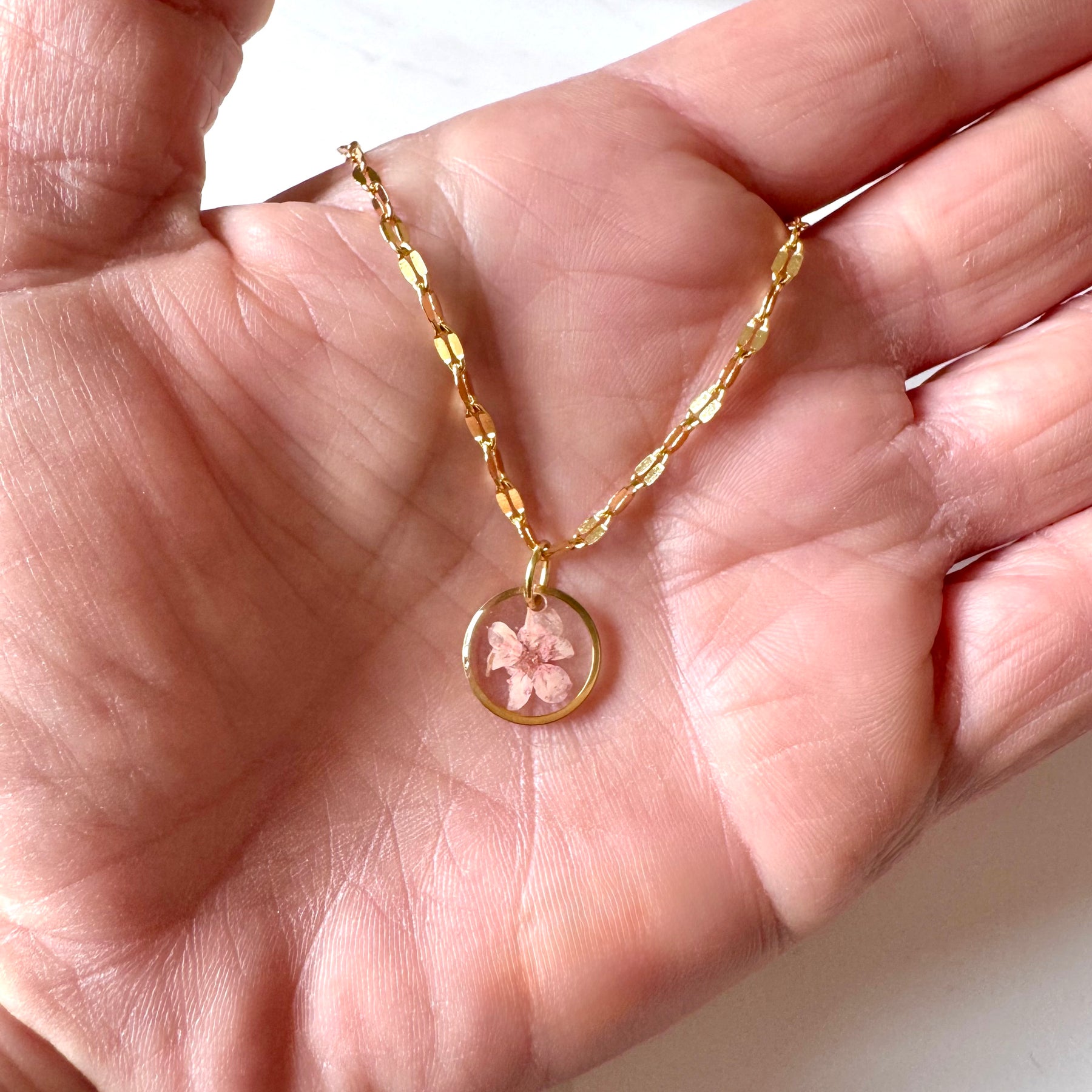 Gold plated resin necklace with pink wildflower