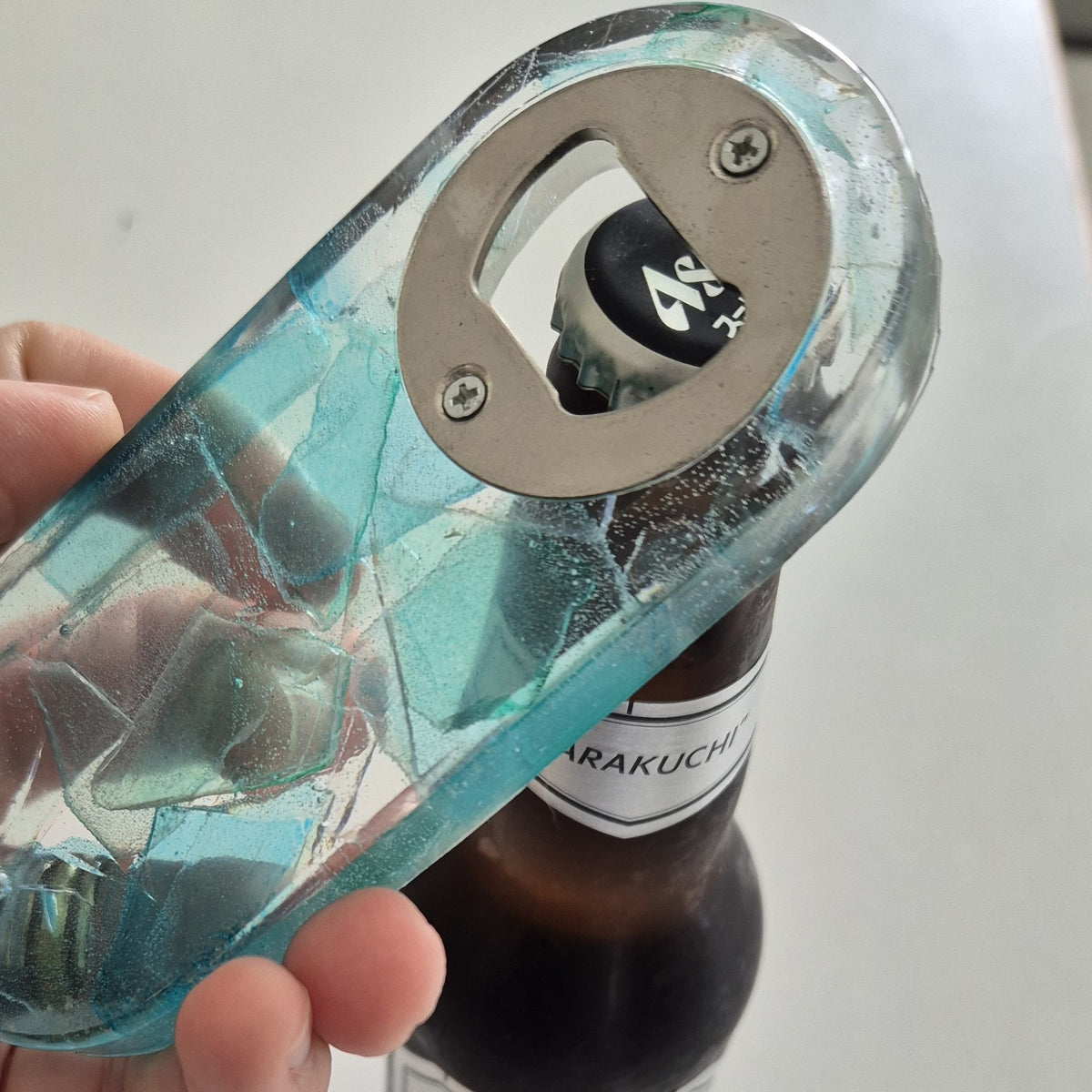 Resin bottle opener with inlaid sea glass