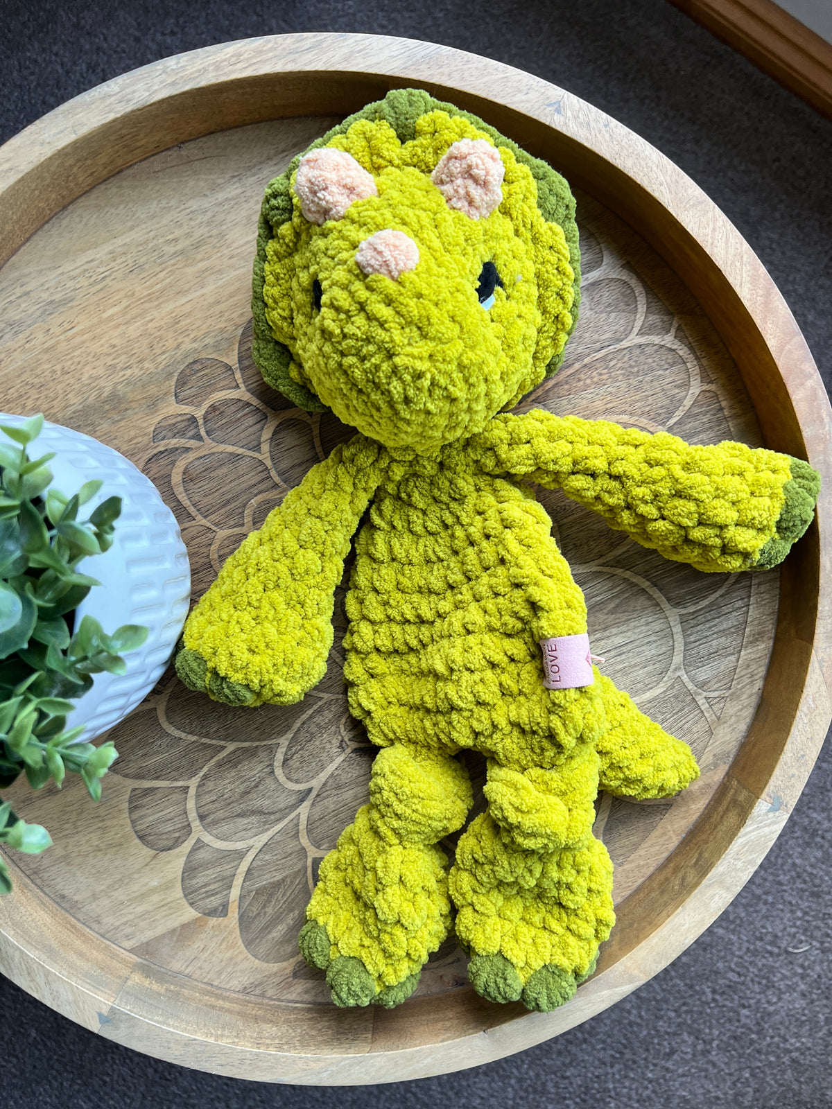 Handmade modern crochet Triceratops lovey snuggler with knotted legs baby safe.
