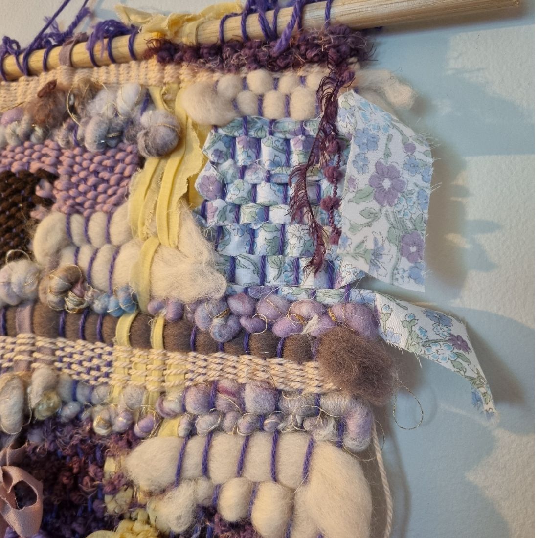 Handwoven textured wall hanging in purple, yellow and brown