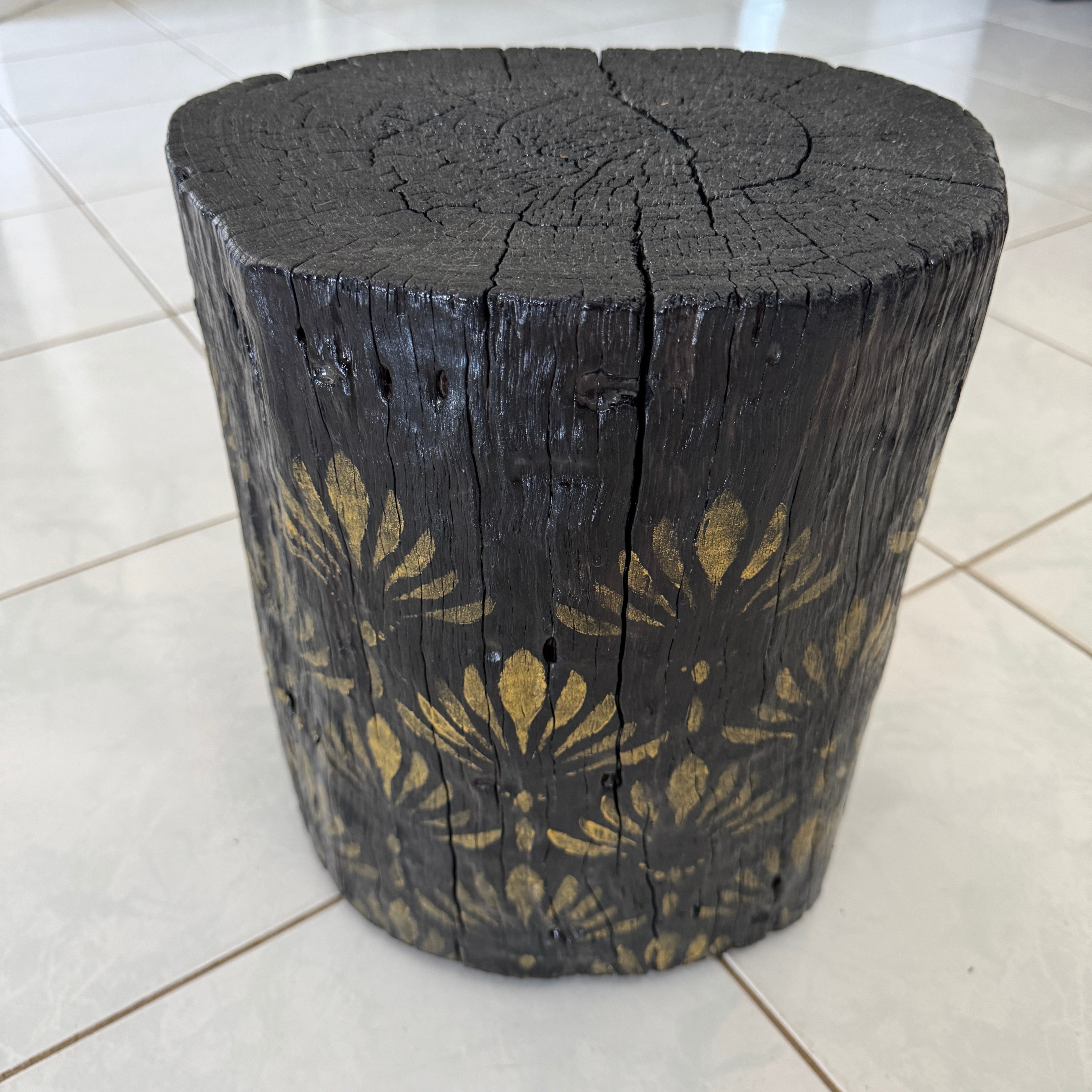 Burnt Timber stump table featuring gold hand-painted artwork