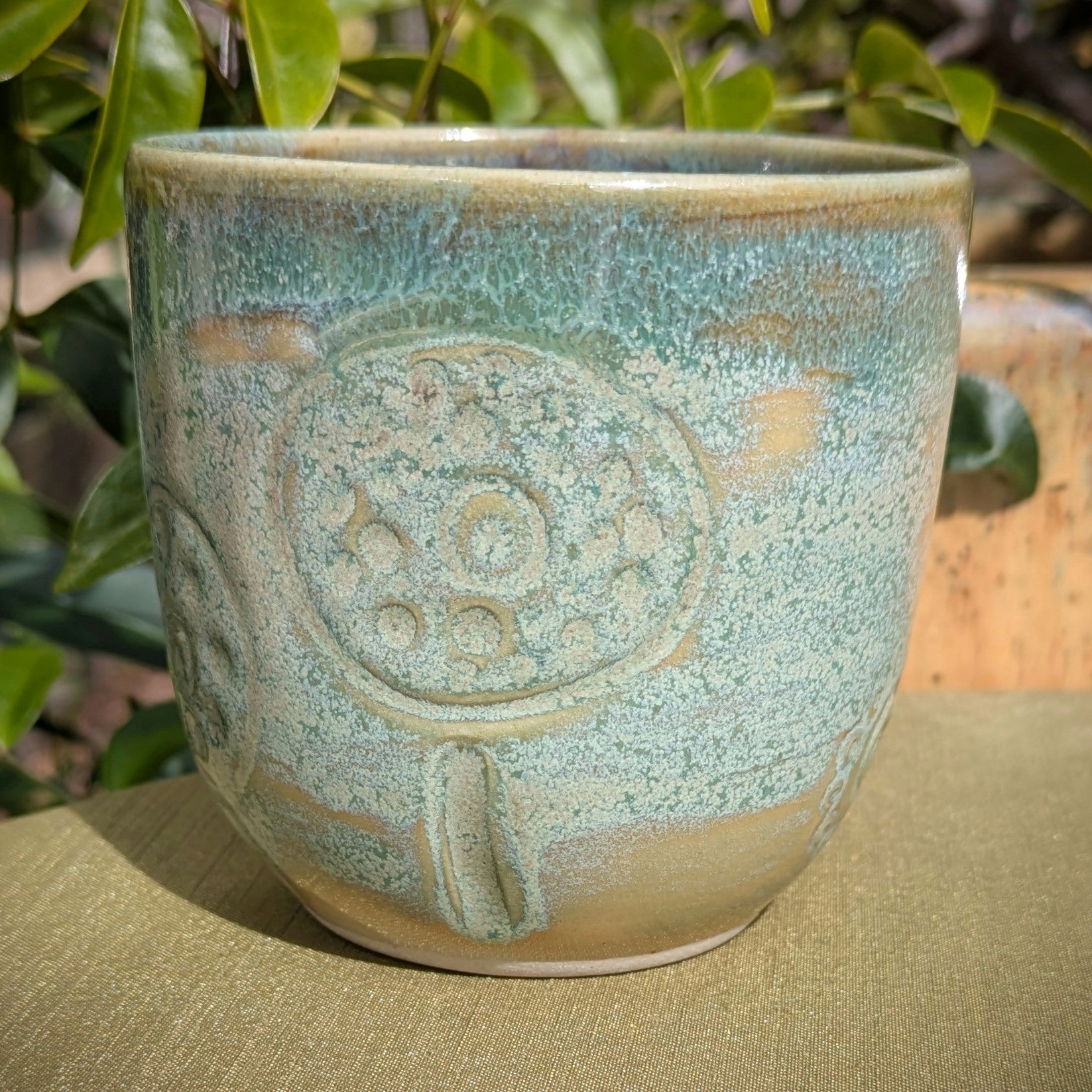 Cup in soft, mottled mossy greens and warm sandy colour