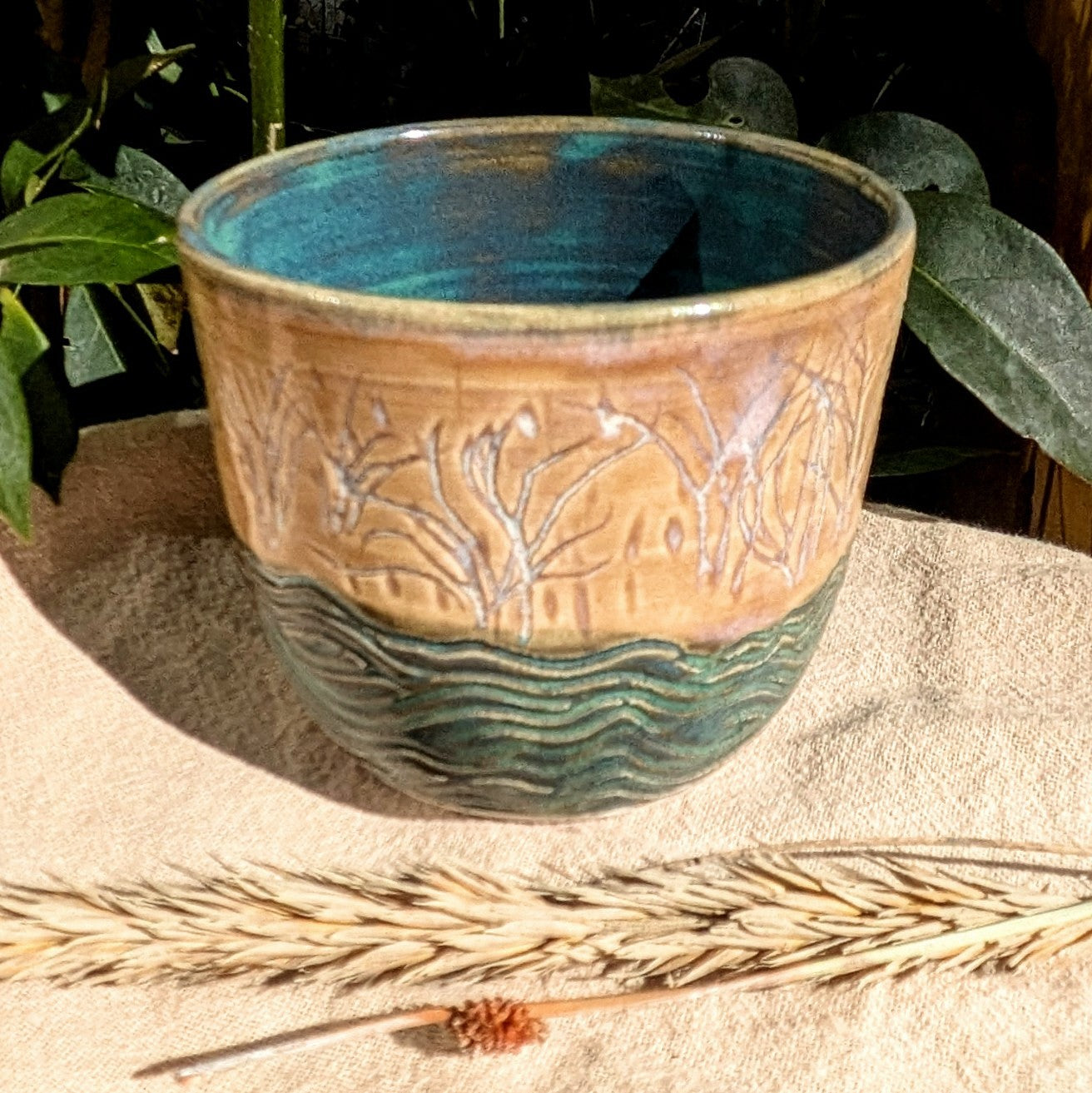 Sand dunes reeds and water tumbler