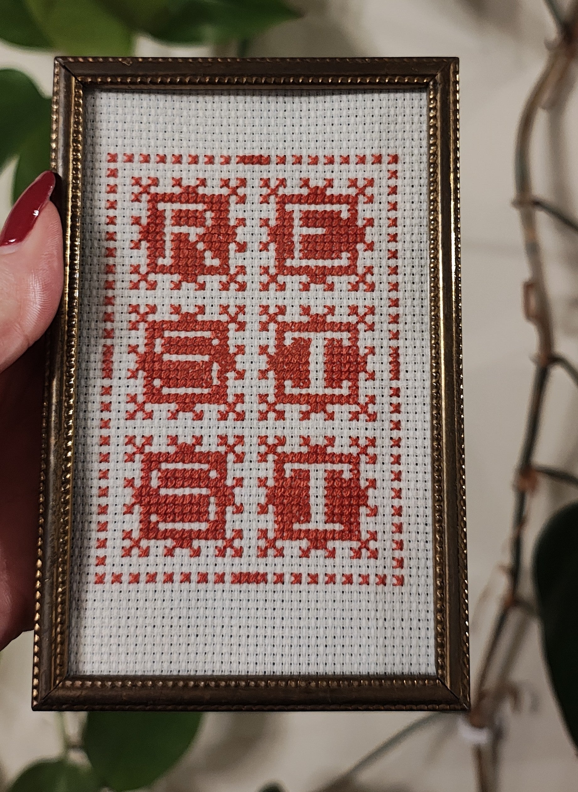 "RESIST" framed cross-stitch