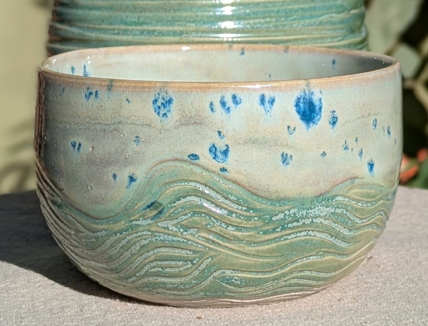 Small bowl in moss green and cream with blue speckles