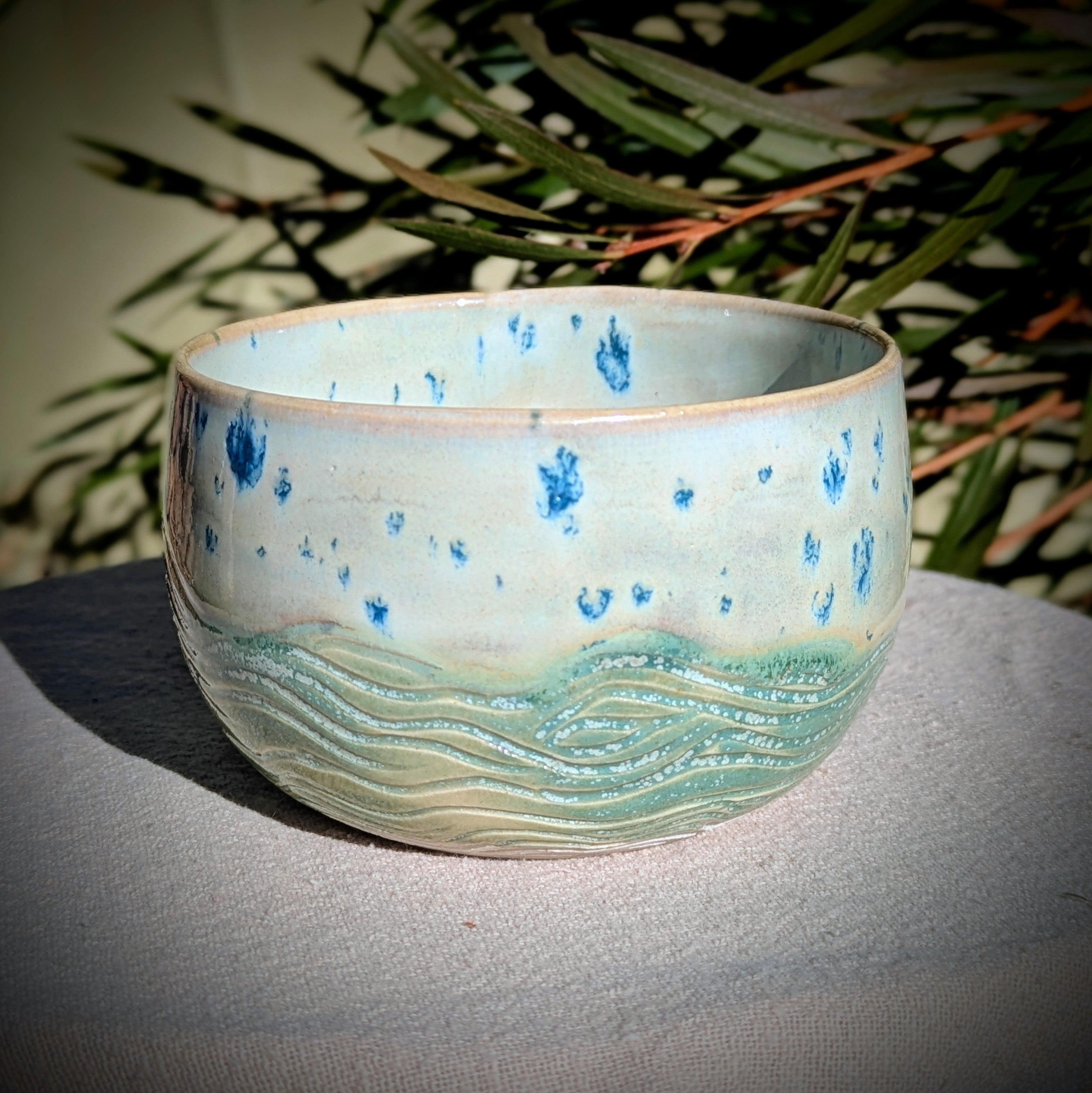 Small bowl in moss green and cream with blue speckles