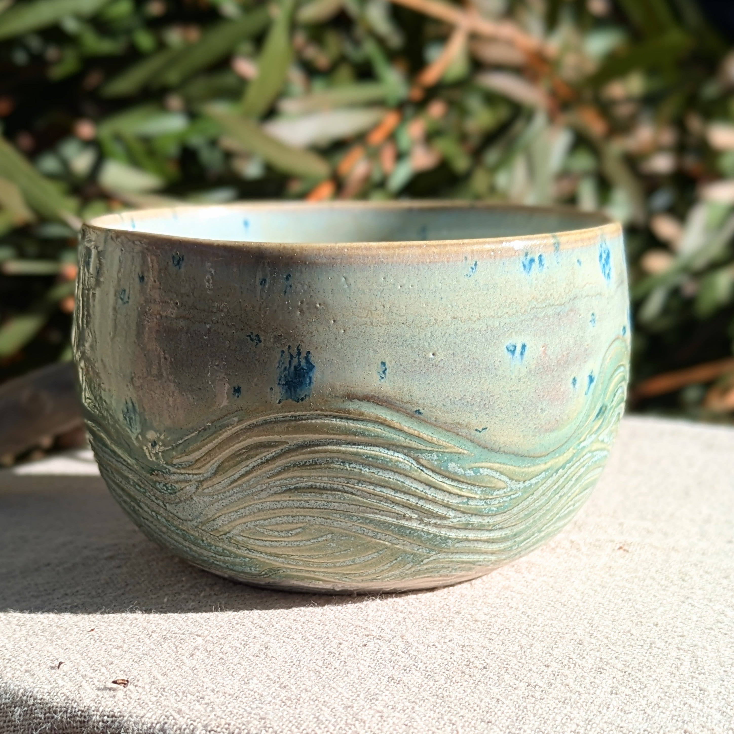 Small bowl in moss green and cream with blue speckles