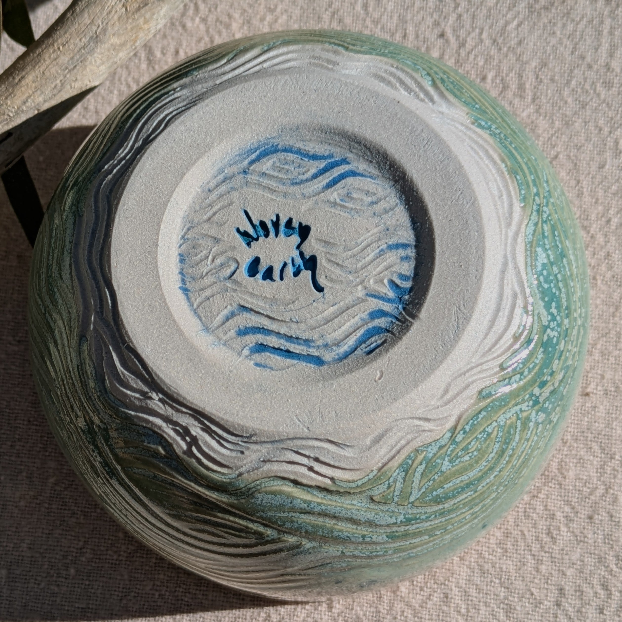 Small bowl in moss green and cream with blue speckles