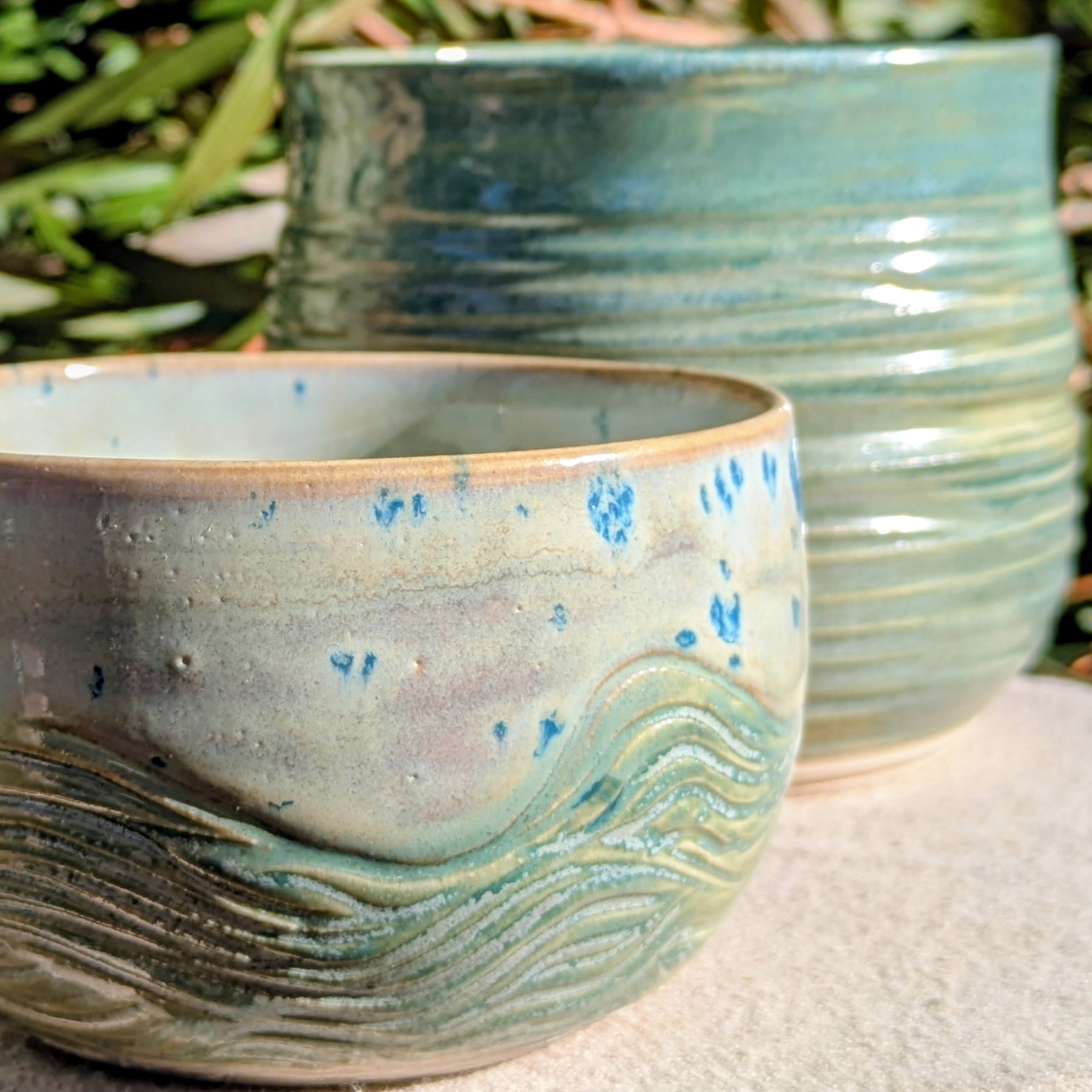 Small bowl in moss green and cream with blue speckles