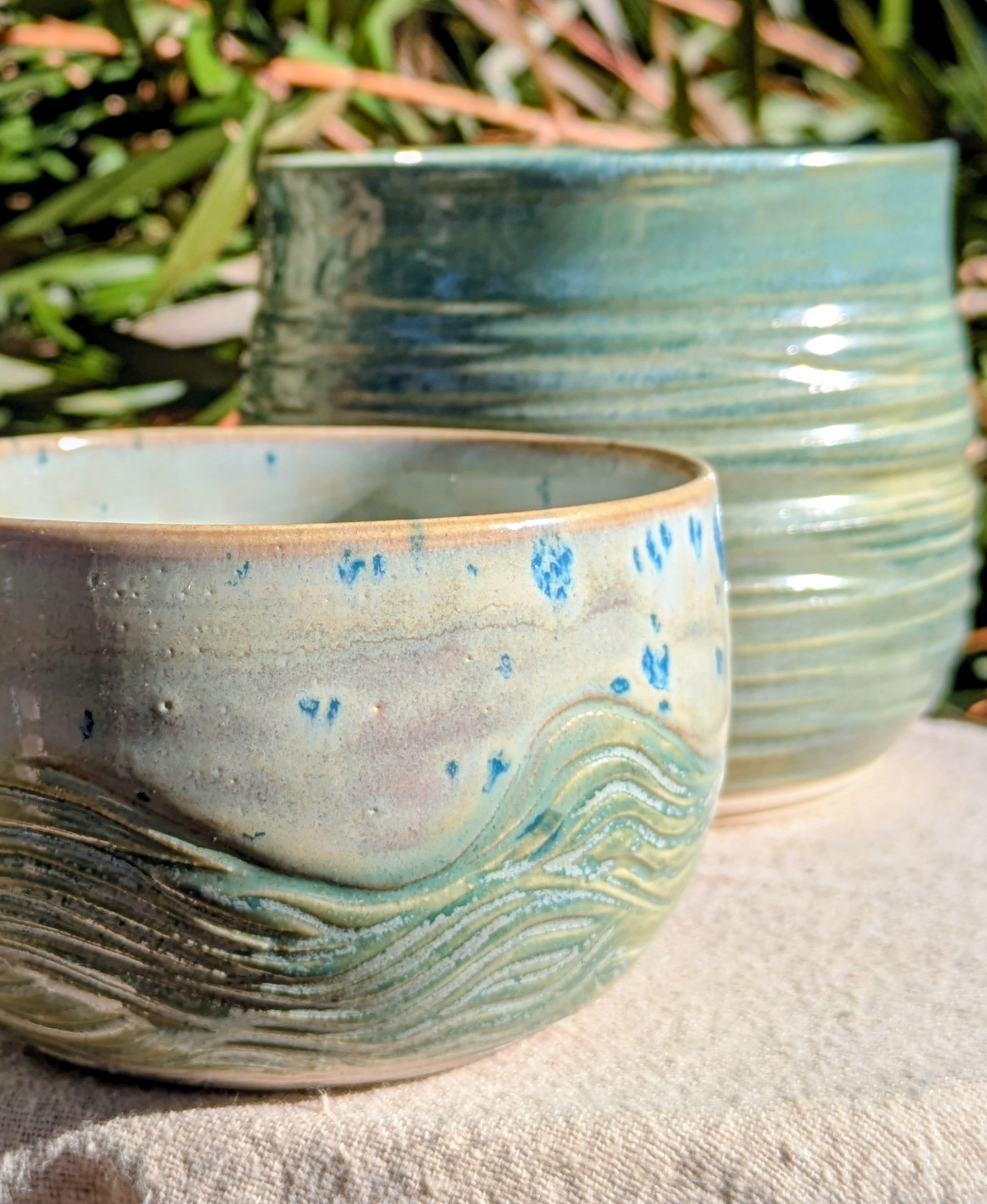 Small bowl in moss green and cream with blue speckles