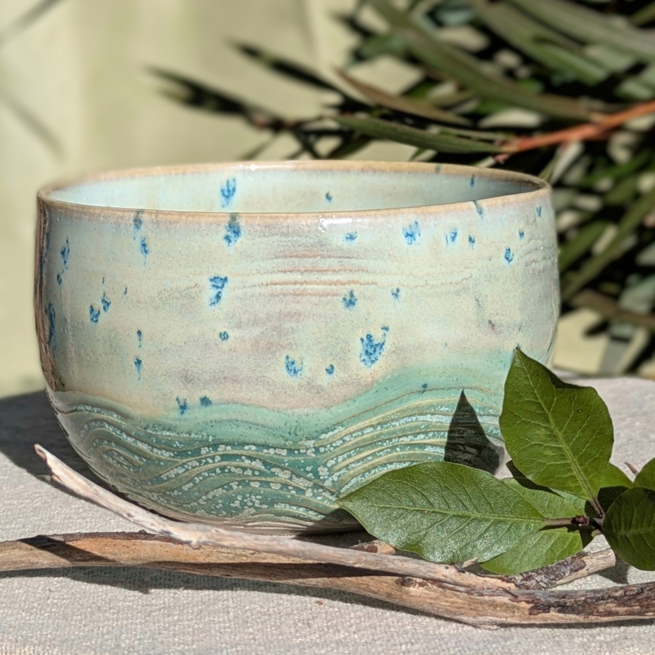Small bowl in moss green and cream with blue speckles