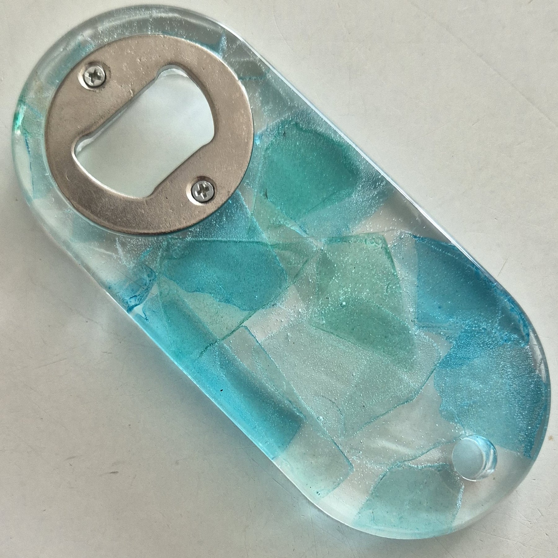 Resin bottle opener with inlaid sea glass