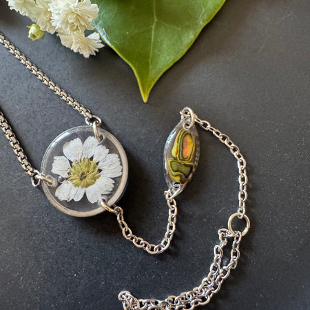 Botanical resin hand chain in silver with pressed flowers and cowrie shell