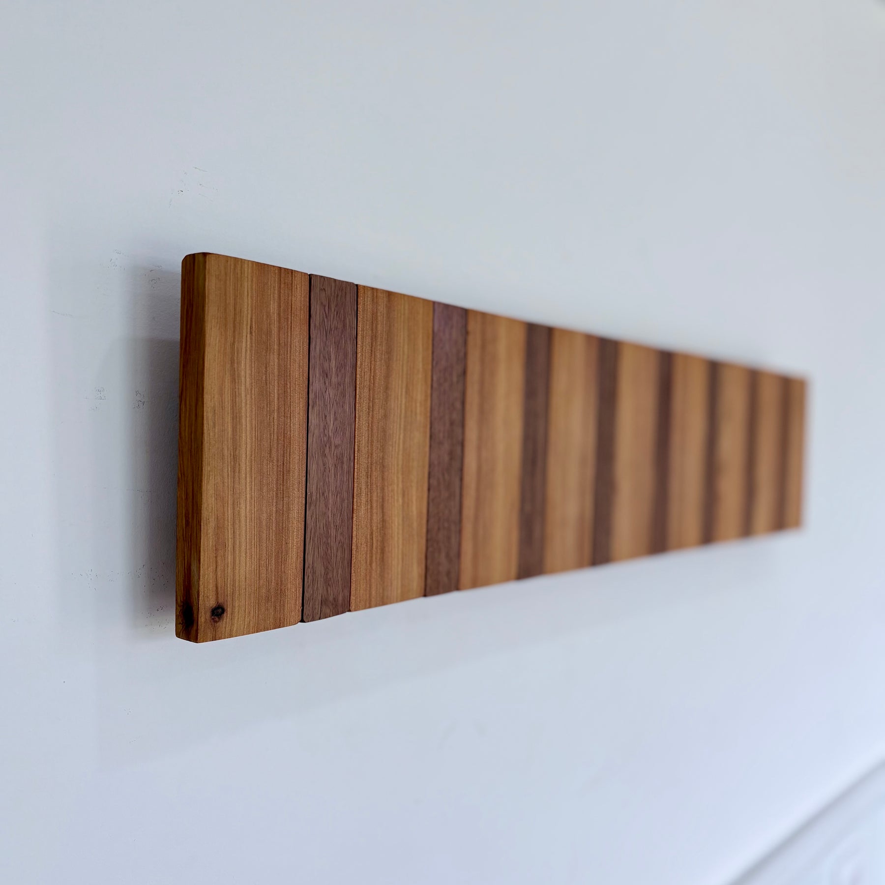 Two tone spotted gum and cypress horizon line piano style coatrack