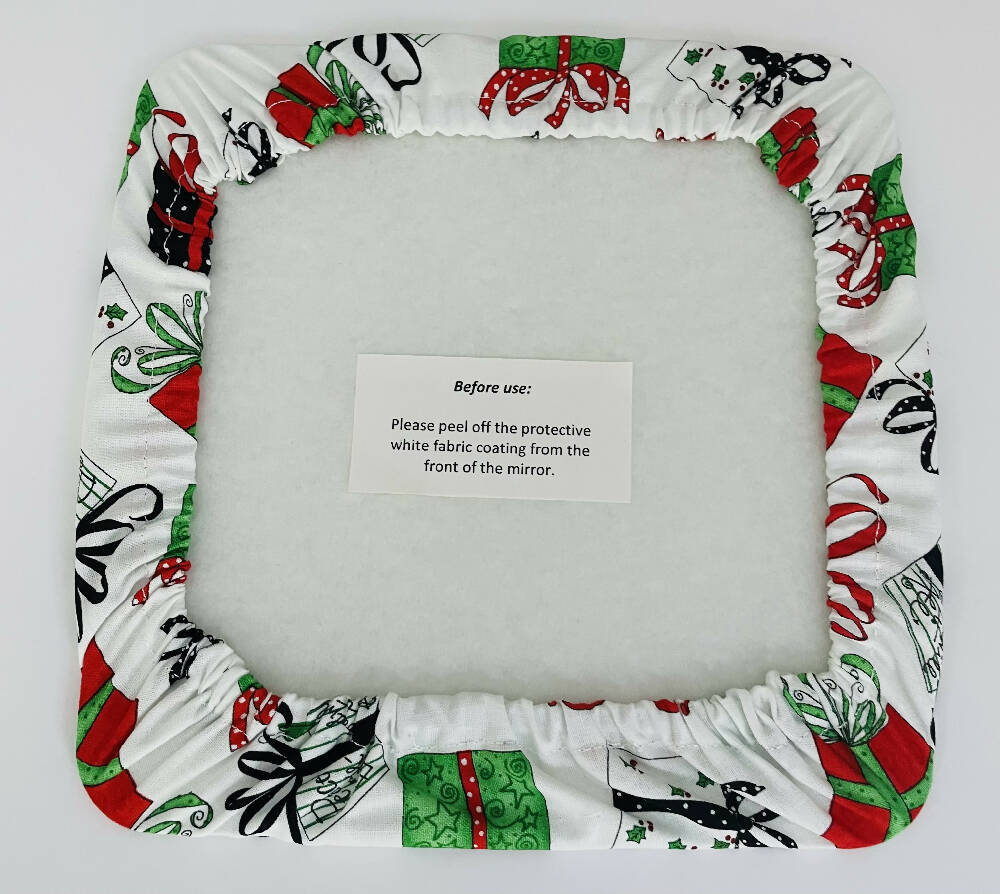 Cotton Casing Mirror play- White fabric with bright Christmas colours with parcels and ribbons. Reds, blacks, green and dots