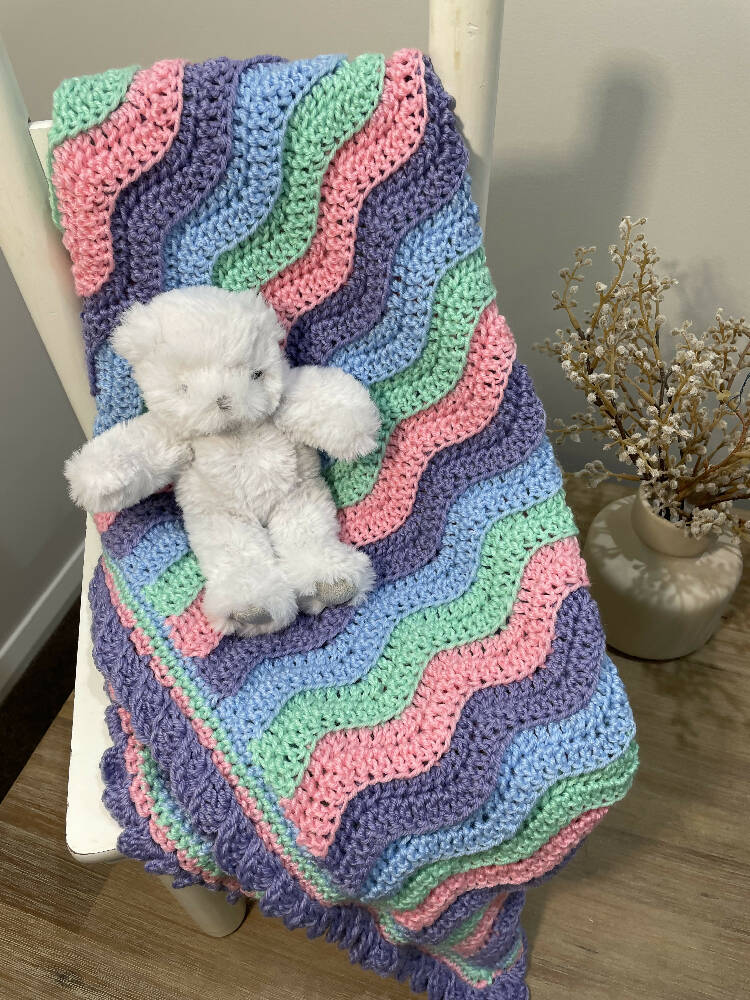 UNICORN BABY BLANKET. Waves of unicorn colours add a touch of whimsy.