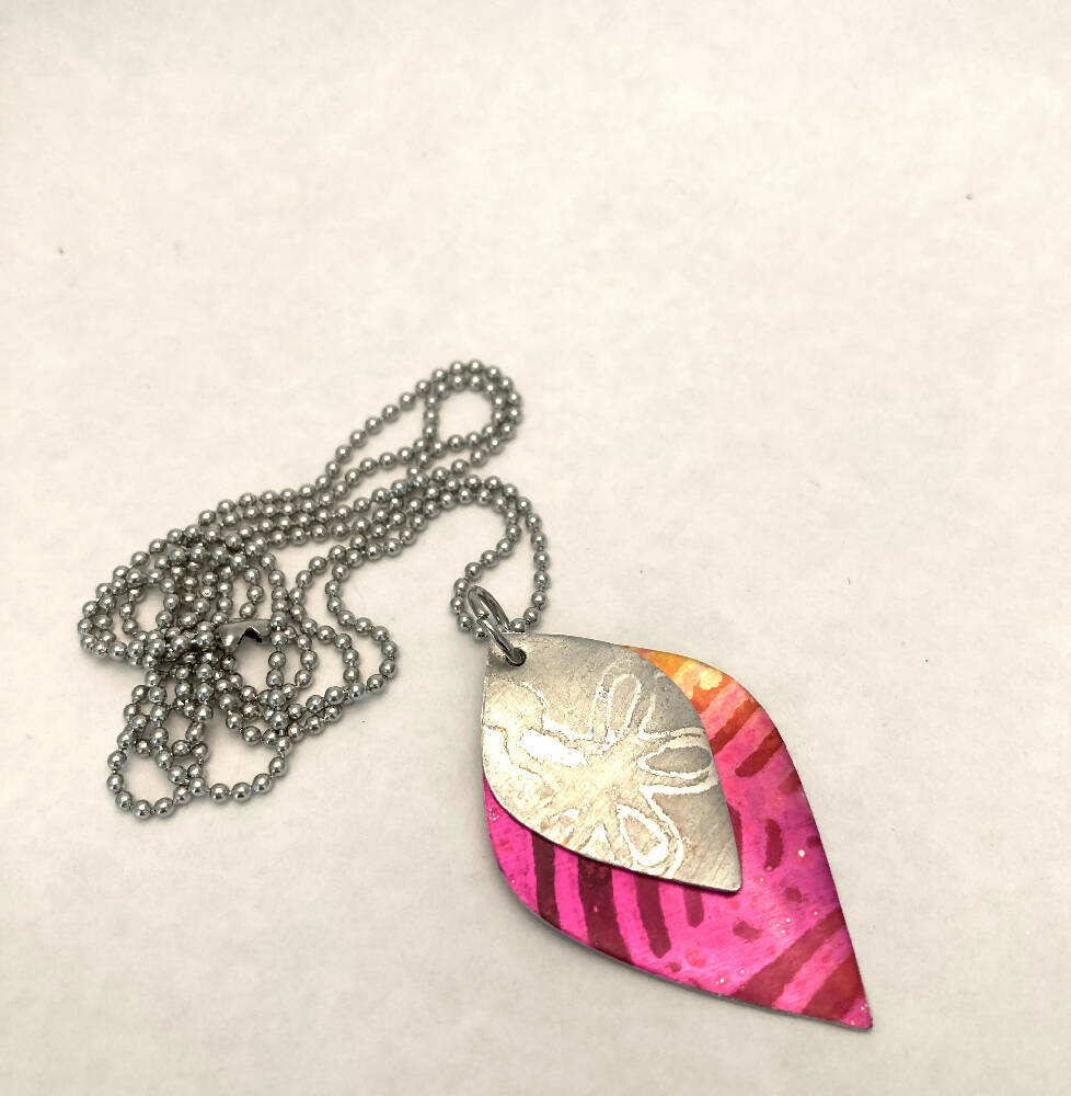 Printed and dyed anodised aluminium with textured flower motif pendant