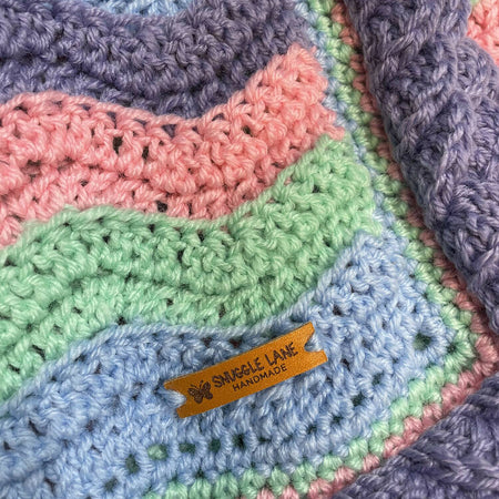 UNICORN BABY BLANKET. Waves of unicorn colours add a touch of whimsy.