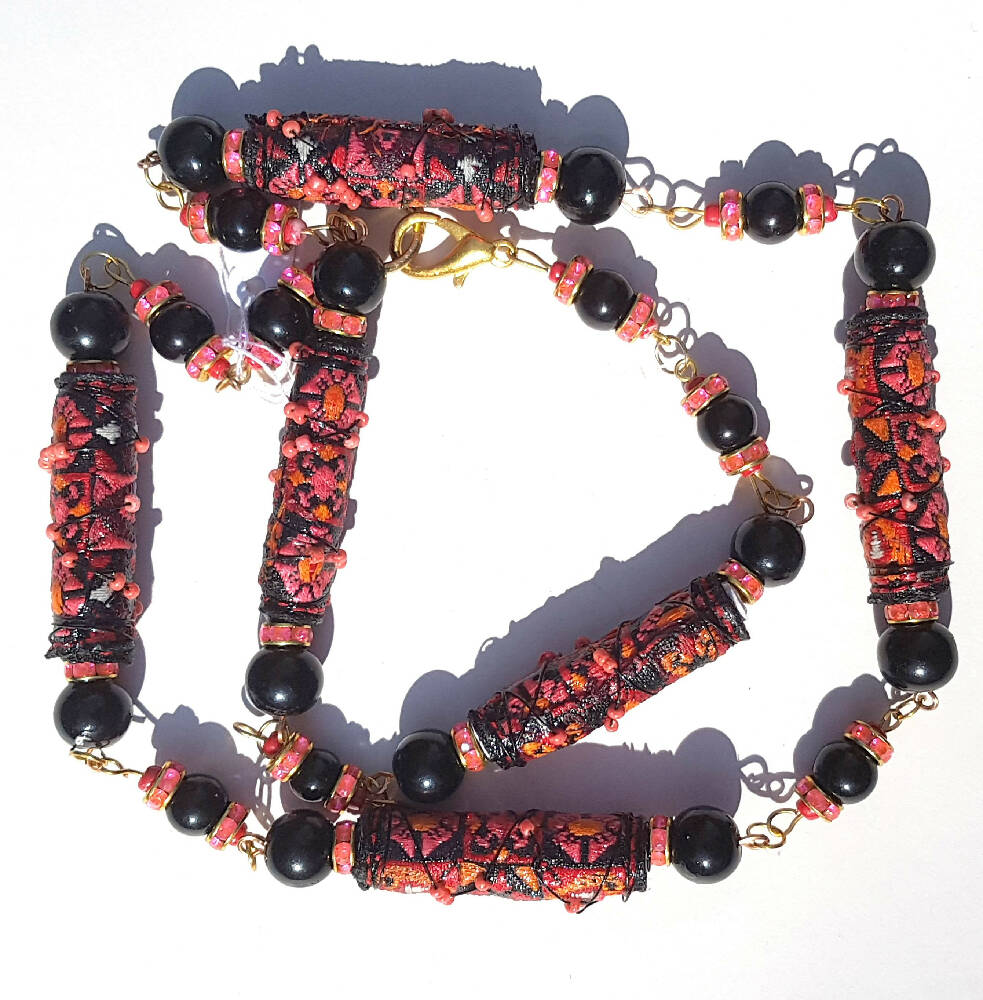 Necklace, beaded. Wire wrapped fabric beads in red and black.