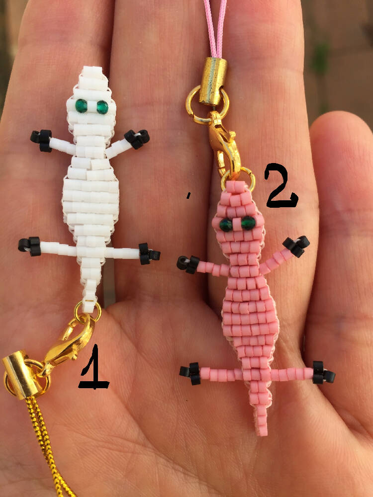 on the palm there are 2 Naryanabeads beaded crocodiles - tiny white and pink ones. Next to the white one number 1, next to the pink - number 2