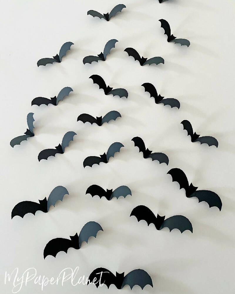 Halloween Bat shapes. Black 3D bats, Spooky holiday decorations.