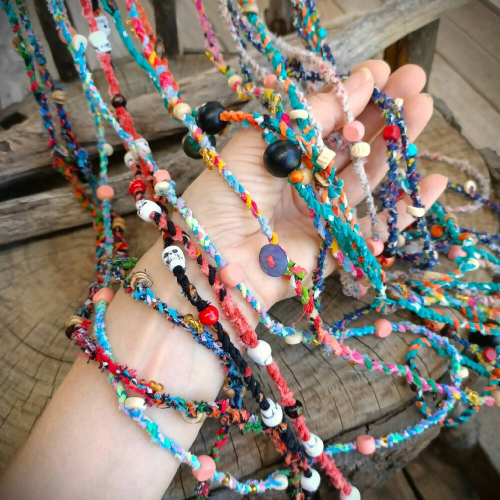 assorted handmade fabric necklaces recycled on arm -