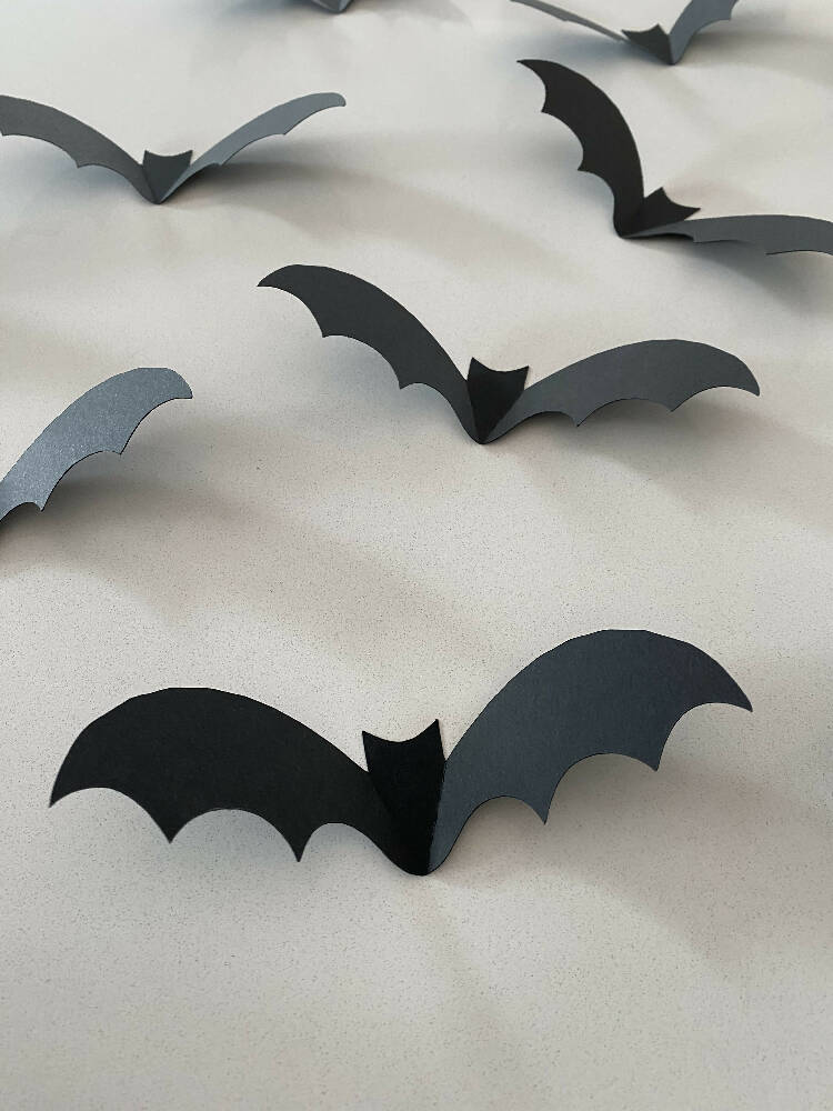 Halloween Bat shapes. Black 3D bats, Spooky holiday decorations.